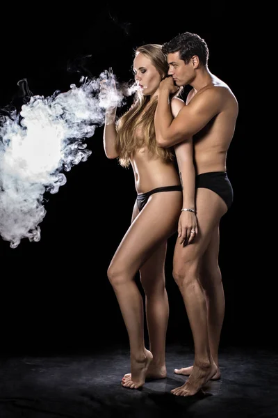 Mulher e o homem voa em um vape fundo preto — Fotografia de Stock