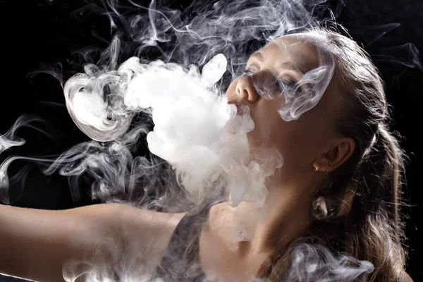 Kız bir siyah arka plan vape yükselir