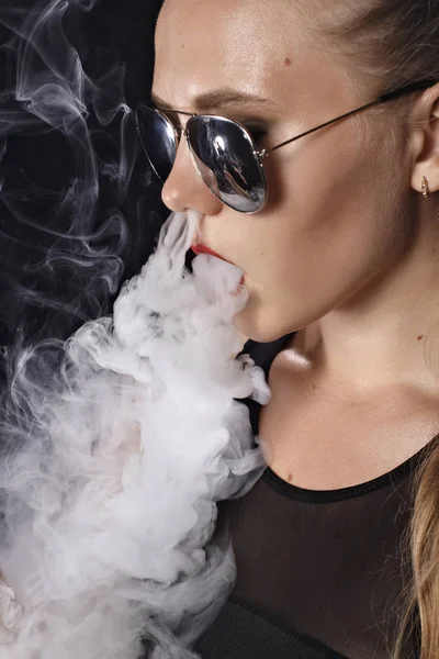 Kız bir siyah arka plan vape yükselir