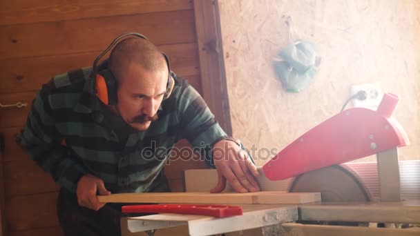 Vet met snor Carpenter Man snijden houten plank met behulp van elektrische jig saw. — Stockvideo
