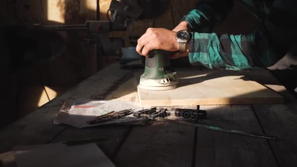 Плотник шлифует деревянные доски в своей мастерской — стоковое видео