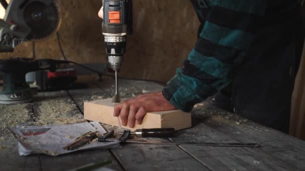Van timmerlieden handen met behulp van boor op houten plank — Stockvideo