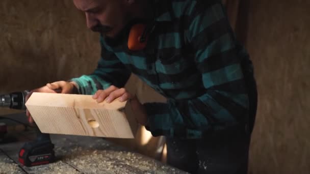 Van timmerlieden handen met behulp van boor op houten plank — Stockvideo