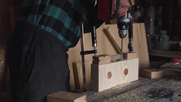 Métier, personnes, menuiserie, menuiserie et concept de personnes - menuisier avec perceuse électrique perçage de planches de bois à l'atelier — Video