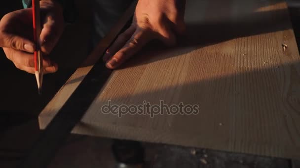 La mano del carpintero tomando la medida de la plancha de madera. sol llamarada ob fondo — Vídeo de stock