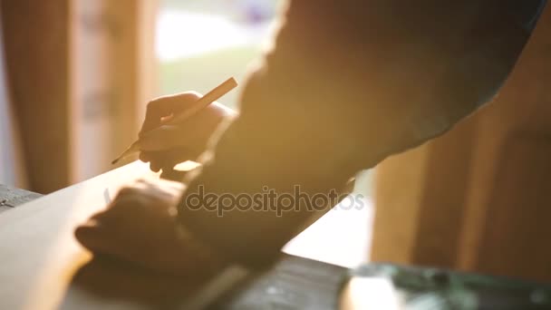 Hand eines Tischlers, der eine Holzplanke vermessen hat. Sonneneruption vor Hintergrund — Stockvideo