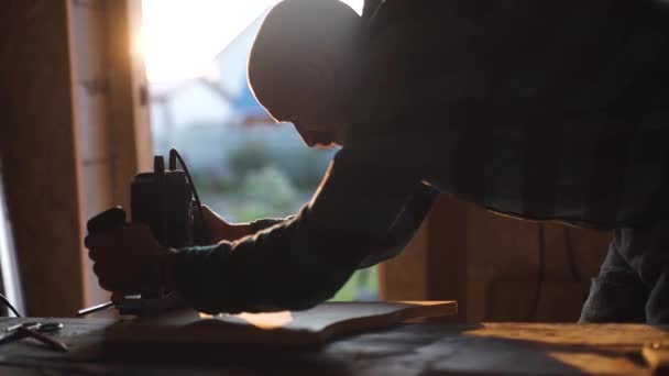 Nahaufnahme von Männern, die mit elektrischer Stichsäge und Holzplanke arbeiten. Sonneneruption auf dem Hintergrund — Stockvideo