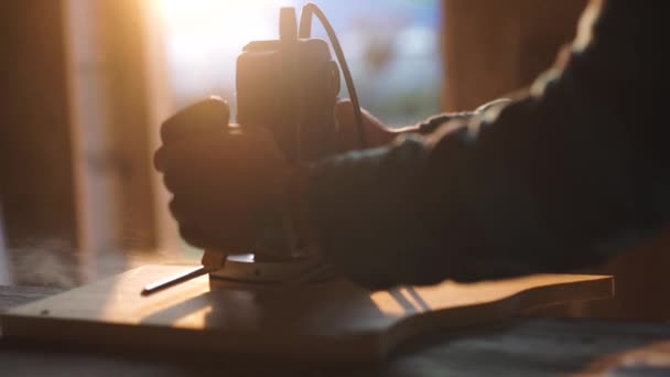 Vista de cerca de los hombres que trabajan con rompecabezas eléctrico y tablón de madera. resplandor solar en el fondo — Vídeo de stock