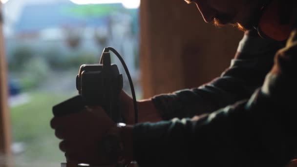 Vista ravvicinata di uomini che lavorano con puzzle elettrico e asse di legno. bagliore di sole sullo sfondo — Video Stock