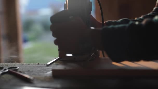 Vista de cerca de los hombres que trabajan con rompecabezas eléctrico y tablón de madera. resplandor solar en el fondo — Vídeos de Stock