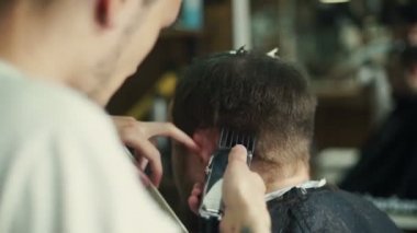 Kuaför saç modeli bir sakallı bir adam yapar.