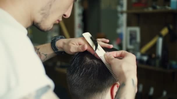 Frisören klipper hår med sax. baksida syn på man i frisör butik. — Stockvideo