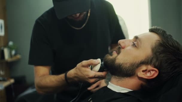 Peluquería corta barba a los clientes en la barbería — Vídeo de stock