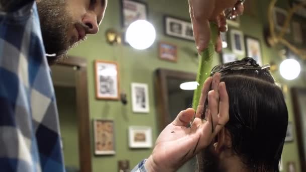 Cabelo longo masculino barbeiro penteando e corte de cabelo de um cliente masculino — Vídeo de Stock