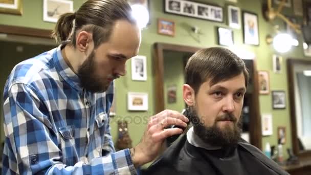 Coiffure concentrée de coiffeur avec rasoir électrique dans le salon de coiffure — Video