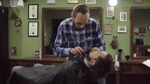 Attrayant barbu homme obtenir sa barbe rasée par barbier moderne dans salon de coiffure — Video