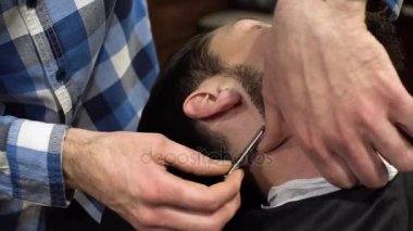 Adam olan kuaför dükkanında tıraş yakın çekim. Profesyonel kuaför Usturanın keskin bıçak ve krem jel ile müşteri yüzüne bıyık, saç kılları kesmek için kullanma. Mutlu gülümseyen memnun Berber Dükkanı