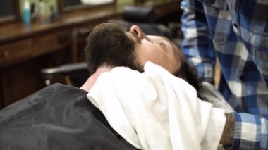 Adam olan kuaför dükkanında tıraş yakın çekim. Profesyonel kuaför Usturanın keskin bıçak ve krem jel ile müşteri yüzüne bıyık, saç kılları kesmek için kullanma. Mutlu gülümseyen memnun Berber Dükkanı