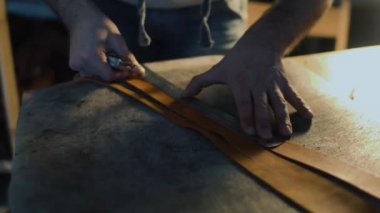 Deri el sanatları veya deri çalışma. güçlü eller mans deri parçası kesme