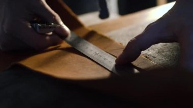 Eller deri bilezik yapmak için bir deri kesme deri sayfanın görünümünü yakın çekim
