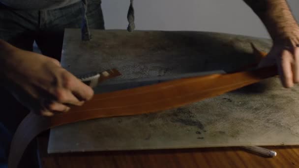 20'li yaşlarda genç adam atölyesinde DIY araçları işçiliği kullanarak deri ile çalışma — Stok video
