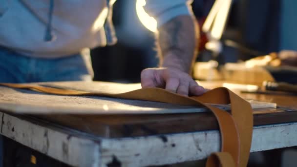 Kožené řemesla nebo kožené pracovní. silné mans rukou je řezaného kusu kůže — Stock video