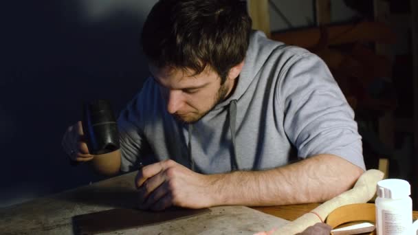 Hombre trabajando en cuero, haciendo agujeros usando hummer — Vídeo de stock