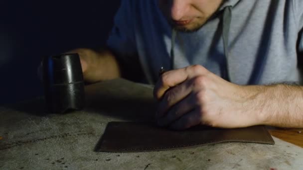 Homme travaillant sur le cuir, faisant des trous à l'aide de hummer — Video