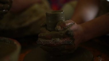 kadının el çanak çömlek tekerlek üzerinde bir tencerede yapar