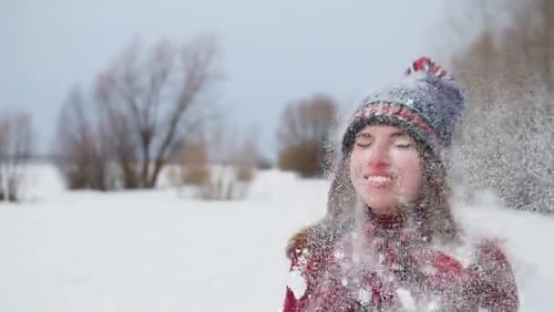 Young happy woman throwing snow up in the air and happy laughing in slow motion 120fps — Stock Video