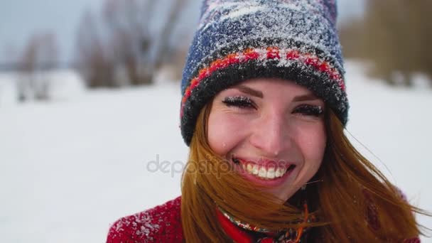 Красивая молодая женщина с длинными рыжими волосами наслаждается зимним днем на улице — стоковое видео