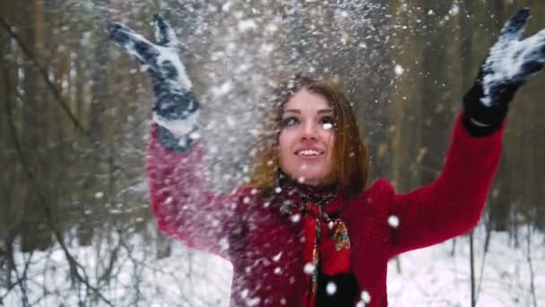 Joven pelirroja pelirroja mujer está lanzando una nieve detrás y reír — Vídeo de stock