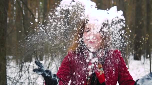 Junge rothaarige Ingwerfrau wirft einen Schnee hinter sich und lacht — Stockvideo