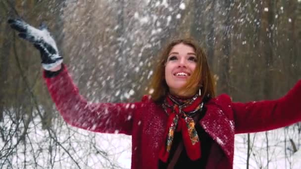 Молодая рыжая рыжая женщина бросает снег позади и смеется — стоковое видео