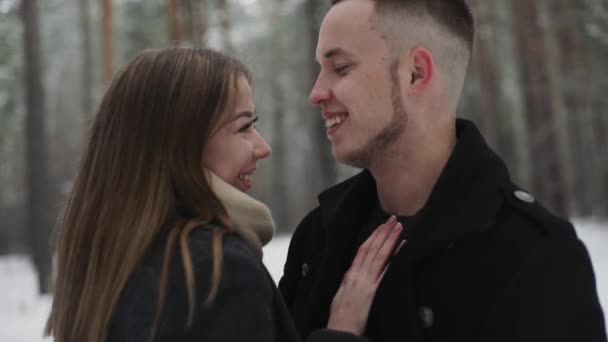 Feliz pareja abrazos y coquetear en el bosque de invierno, sonriendo — Vídeos de Stock