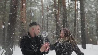 20'li yaşlarda genç çift arkasında atmak kar ve kış ormanda eğlenin