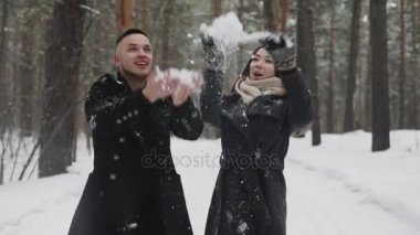 20'li yaşlarda genç çift arkasında atmak kar ve kış ormanda eğlenin