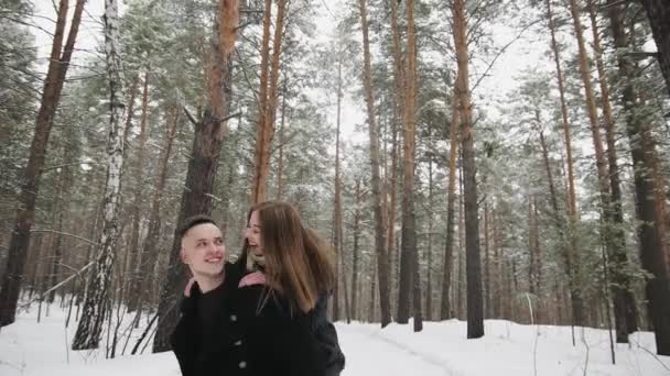 Outdoor happy laughing couple is having a fun in a winter snow forest — Stock Video