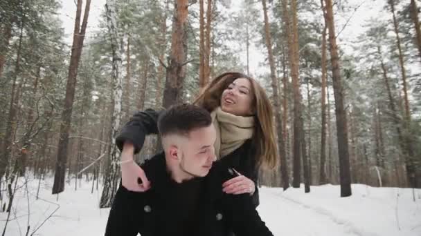 Outdoor happy laughing couple is having a fun in a winter snow forest — Stock Video