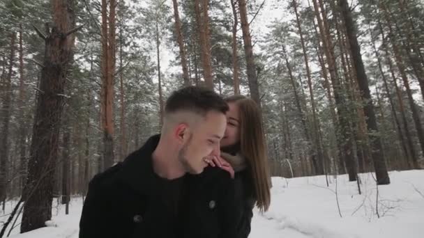 Utomhus lyckligt skrattande par är att ha en rolig i en vinter snö skog — Stockvideo