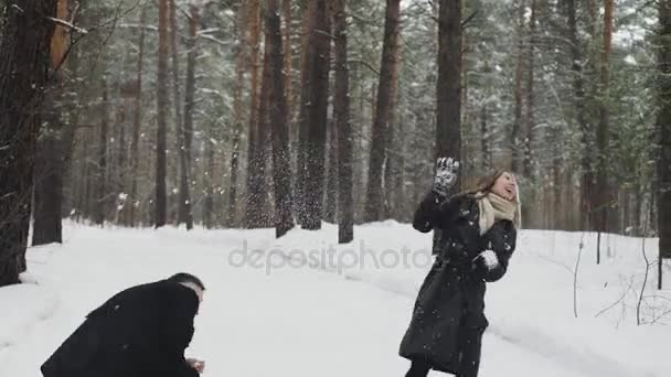 Homme et femme couple est lancer boules de neige à l 'autre ensemble dans une neige hiver forêt — Video