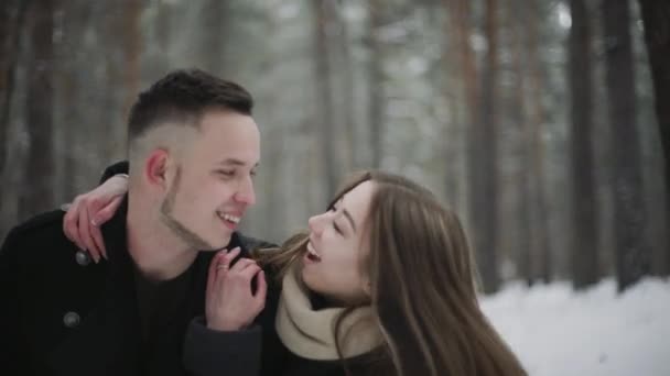 Ao ar livre feliz rindo casal está se divertindo em uma floresta de neve de inverno — Vídeo de Stock