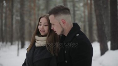 Sevgilisini kış orman ile konuşan adam ve çevresinde bir şey gösterir