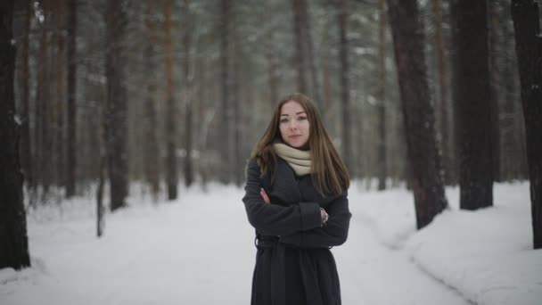 Soleado retrato de invierno al aire libre de la joven mujer atractiva de los años 20. Chica bonita sonriendo en invierno en el bosque — Vídeos de Stock