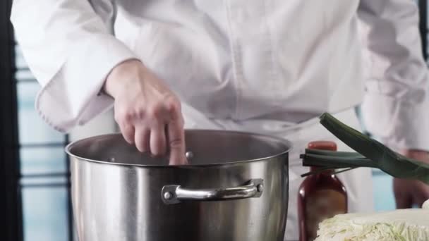 Chefs hands cooking soup, mixing with wooden spoon at modern kitchen — Stock Video