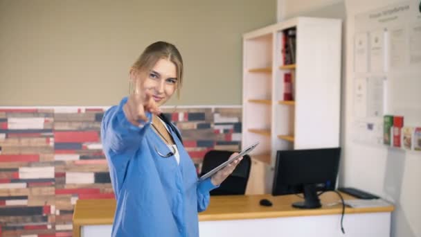 Portret van jonge vrolijke verpleegster in een blauwe medische uniform.4k — Stockvideo