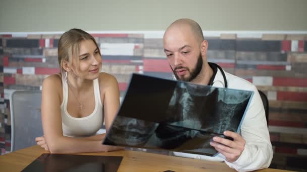 Łysy 30s dorosłych lekarz jest Wyświetlono rentgenowskie do pacjenta i omówić — Wideo stockowe
