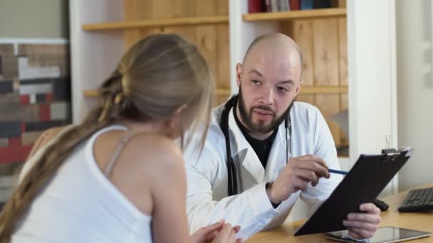 Médico profesional adulto discutiendo con mujer mujer paciente en consultorio médico con tableta 4k — Vídeos de Stock