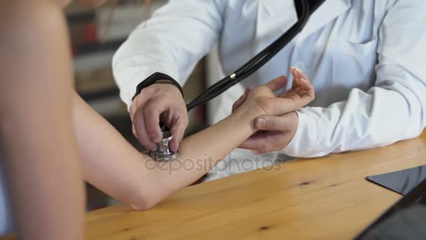 封闭的一位男医生的手用听诊器 4 k 测量脉冲 — 图库视频影像