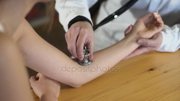 Close up of a male doctor hands is measuring pulse with stethoscope 4k — Stock Video